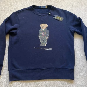 Polo Bear By Ralph Launen Sweatshirt // Tröja Navy - Säljer en snygg mörkblå tröja från Ralph Lauren med ett coolt nallemotiv på framsidan. Tröjan är i nytt skick och har långa ärmar. Perfekt för höst och vinter! 🐻💙