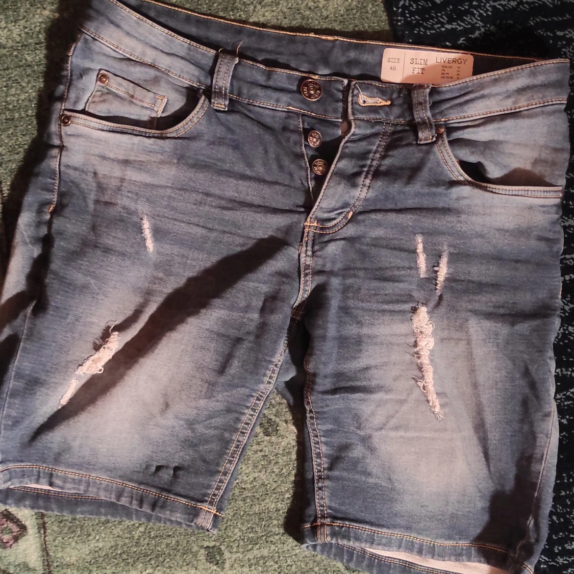 Blå jeansshorts med slitningar