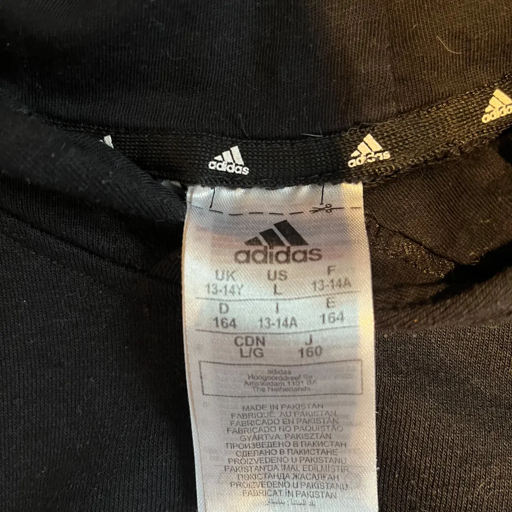 Säljer en svart hoodie från Adidas i storlek S Den har en stor vit logga på framsidan och är perfekt för både träning och vardag. Materialet är mjukt och bekvämt, och den har en klassisk passform med långa ärmar och huva. Perfekt för höst och vinter!. Tröjor & Koftor.