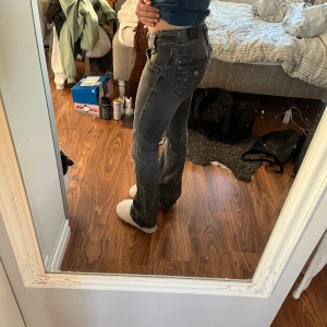 Lågmidjade bootcut jeans - Grå lowwaist från Lee. Toppen skick! Storlek W27L31 passar från ca 157-165cm. Jag är 159cm lång och de är något långa men går snyggt över skorna. Bär XS-S i vanliga fall