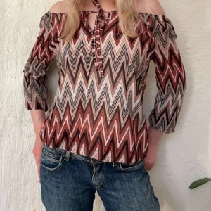 Missoni liknande topp  - Säljer en superfin offshoulder topp från Haily's i storlek XS men passar S med💕 mönstret likar Missonis så mycket💗 Toppen har trekvartsärmar och en söt knytning framtill. Men kan ha den offshoulder eller vanligt💕 så fin och trendig 💕