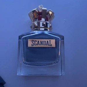 Scandal Eau de Toilette pour Homme från Jean Paul Gaultier - Säljer en elegant herrparfym, Scandal, från Jean Paul Gaultier. Flaskan har en unik design med en krona som lock och röd detalj. Förpackningen är djup röd med silvertext. Innehåller 100 ml av en doft som utstrålar självsäkerhet och stil.Endast använd 2 gånger. Kan gå ner i pris vid snabb affär