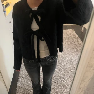 Svart kofta med knyt från Gina - Söt svart kofta från Gina med knyt framtill, perfekt för en stilren look. Koftan är i nyskick är använd 1 gång skick 10/10. Storlek xs men skulle säga att den även passar S💕Köpt för 400kr💕