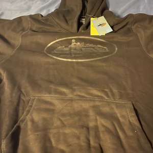 Corteiz tröja ny - Säljer en svart hoodie med. Den har en klassisk känguruficka och en bekväm huva. Perfekt för en avslappnad stil.