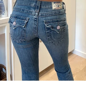True religion jeans - Lånade bilder!! Snygga blåa true religion jeans med låg midja och straight-stil. Knappen där framme är lös men går att sy på bättre. Jeansen är i storlek 24(xs) och de har slits i buntarna så att de ska gå över skorna🥰köpte dem för 200€ som använda