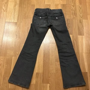 Gråa  bootcut och low waist jeans från Gina Tricot - Snygga gråa bootcut jeans från Gina Tricot med dubbla knappar och klassiska femficksdesign. Perfekta för en stilren look.❤️