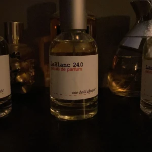 LeBlanc 240 Eau de Parfum - Elegant och sofistikerad parfym från LeBlanc med en minimalistisk design. Flaskan är genomskinlig med en enkel vit etikett och svart text. Perfekt för den som söker en unik doftupplevelse.