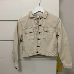 Beige jacka från Lindex - Säljer en beige jeansjacka från Lindex i storlek 158. Jackan har långa ärmar och knappar framtill samt två bröstfickor. Perfekt för vår och höst! Skulle säga att den passar bra till någon som har XS🩷🩷