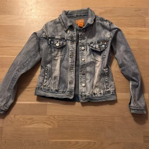 Jeansjacka från Bulldozer - Snygg jeansjacka från Bulldozer i klassisk blå denim. Jackan har knappar framtill och två bröstfickor med knappstängning.