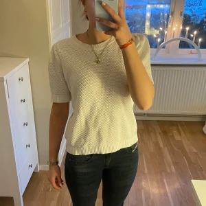 Vit stickad tröja från Vila - Säljer en stilren vit stickad tröja från Vila. Tröjan har korta ärmar och en rund halsringning. Den är i storlek M, men passar även de i s och xs