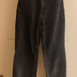 Svarta jeansbyxor från H&M - Snygga svarta jeansbyxor från H&M med hög midja och justerbar midja. Byxorna har en rak passform och klassiska femficksdetaljer.  Super sköna!