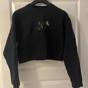 CK tröja  - Croppad Calvin Klein tröja, knappt använd, storlek L men passar även M. Lite mer svart grå än svart i färgen.