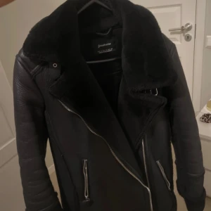 Svart skinnjacka med pälsdetaljer - Vinterjacka med läder och päls från stradivarius i storlek S. 