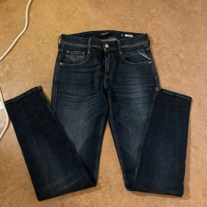 Mörkblå jeans från Replay - Tja säljer ett par snygga mörkblå jeans från Replay, modell Anbass. De har en klassisk femficksdesign och dragkedja. Perfekta för en stilren look. Helt nya aldrig använda