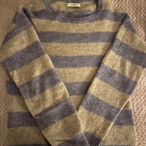 Randig tröja från Sissy-Boy - Mysig randig tröja från Sissy-Boy i lila/blått/blågrå och beige. Tröjan har långa ärmar och en rund halsringning. Perfekt för kyligare dagar. Storlek S. Pris går att diskuteras.