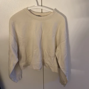 Beige sweatshirt från Zara - Säljer en beige sweatshirt från Zara i storlek M. Tröjan är en kort model.
