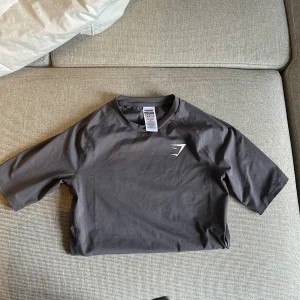 Grå träningstopp från Gymshark - Säljer en grå träningstopp från Gymshark i storlek XS. Toppen har korta ärmar. 