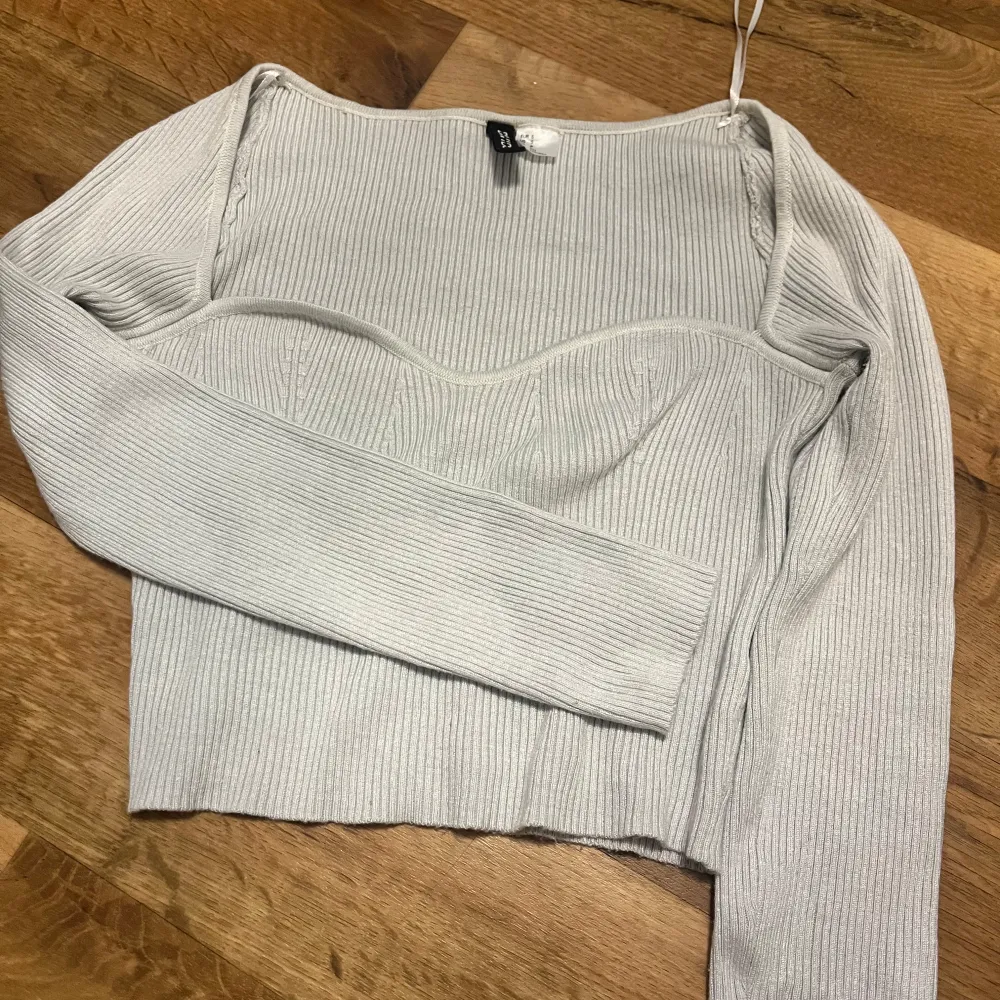 Snygg vit ribbad topp från H&M med långa ärmar och en croppad design. . Yläosat.