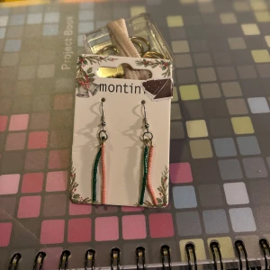 Flerfärgade örhängen  - Snygga örhängen med hängande detaljer i rosa och grönt. Perfekta för att ge en färgklick till din outfit.