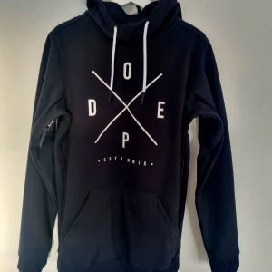 Snowboardjacka Dope Yeti XS - Svart snowboardjacka från Dope, modell Yeti (herr), storlek XS. Stor ficka fram samt ficka på ärmen, huva och hög krage. Fodrad insida.. Mycket fint skick.