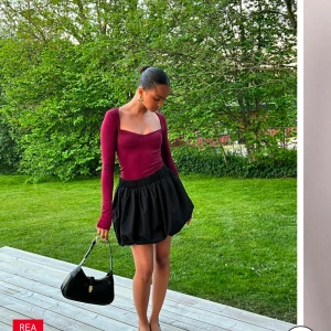 Vinröd långärmad topp - Snygg vinröd långärmad topp med en smickrande fyrkantig urringning. Perfekt för både vardag och festliga tillfällen. Passar bra med både kjol och jeans.