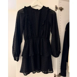 Y Long sleeve frill dress black - En svart klänning från Gina tricot. I storlek 146/152 (barn storlek). Aldrig använd prislappen är kvar. Inga skador på den osv. 