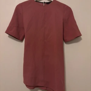 Rosa klänning från Zara Woman - Säljer en rosa blus från Zara Woman med korta ärmar och knytband bak. Aldrig använt bara provat😊