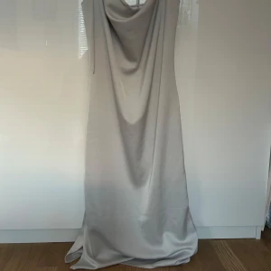 Klänning satin från weekday - Populär klänning från weekday i créme färg i satin. Otroligt somrig och fin. Passar till examen, sittningar, midsommar och födelsedagar samt sommarkvällar. 