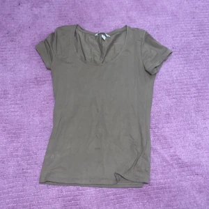 Basic T-shirt - Vanlig T-shirt med djup rund krage. Täcker över naveln. Den är typ ljusbrun och jätteskön och stretchig