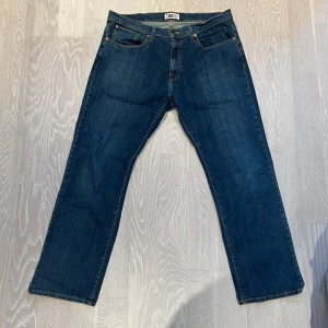 Mörkblå jeans från US Top Denim - Säljer ett par mörkblå jeans från US Top Denim i storlek 40/32. De har raka ben men kan passa som ”baggy” byxor, vilket ger en klassisk look. Perfekta för vardagsbruk och kan enkelt matchas med olika outfits🥰 Innerbenslängd: 75cm