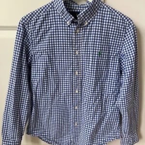 Polo Ralph lauren skjorta  - Väldigt fräsch Ralph lauren skjorta! Skjortan är blå rutig och storleken är L(14-16) alltså barn storlek!