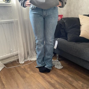 Blå bootcut jeans från brandy - Ett par blåa jeans som har en urtvättad färg, det finns snörning på insidan i midjan (bild 3) så de kan dras åt. De är lite stretchiga, det syns att de är använda då de var för långa på mig och har blivit slitna längst ner på baksidan. 