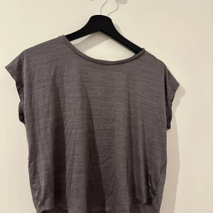 Grå t-shirt - Säljer en enkel och bekväm grå tränings t-shirt. Den är kortärmad och har en lös passform. Materialet känns mjukt och skönt mot huden.