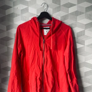 Röd zipup - Fin röd zipup i bra skick som ej kommer till användning, vet inte vilket märke de är då jag köpte den secondhand. Strl L men jag som brukar ha S kan ha den o då blir den lite oversized 