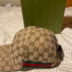 Gucci Baseball Keps - Säljer min gucci baseball keps i beige! Den är självklart äkta, dock ingen kvitto mer har bevis i dms! Skada på båda sidorna på kepsen ( se sista bilden). inget man ser eller märker!  Samt missfärgning på insidan när den tvättades, därav priset!