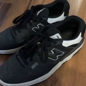 Säljer ett par snygga New Balance 550 sneakers i svart och vitt. De har en klassisk design med snörning och en bekväm passform. Perfekta för vardagsbruk eller träning. Skorna är i bra skick och redo för nya äventyr! Priset kan diskuteras det är inte hugget i sten