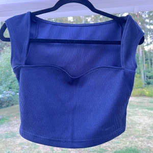 Croppad mörkblå topp - En croppad mörkblå topp som är använd max 3 gånger 🌺 Säljer pga att den inte kommer till användning längre! Passar bra till mig som bär storlek S 🥰  Längd: 33 cm