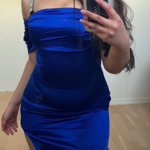 Marin Blå klänning - ÄLSKAAR denna klänningen men den har blivit för liten på mig. Har använts endast en gång, ser helt ny ut.Klänningen har även en korsett inbyggd i klänningen som framhäver kurvorna. Även en slits vid sidan om, ända upp till höften. Kan användas som XS