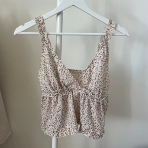 Blommig topp - Rosa, blommig topp köpt på Sellpy. Okänd storlek men passar mig som S/M. 
