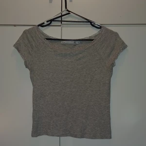 Grå kort t-shirt - En kortare grå t-shirt. Den är använd 1 gång men jag själv gillade inte att den var så kort. Den är perfekt till vardags. Jag minns inte vad jag köpte den för men wftersom den är secondhand så tänker jag sälja den extremt billigt