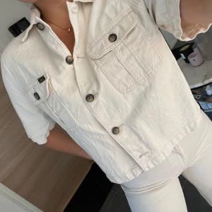 Mjuk jeansjacka/överdel från Lee - Snygg, helt oanvänd, vit kortärmad jeansjacka från Lee. Den är helt slutsåld och finns inte längre att köp, köptes för 999, säljs för 400kr. Snygg att ha som överdel till jeans & kjolar, men även snyggt med linne eller tisha under!