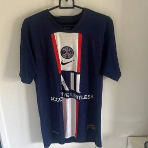 Säljer en snygg blå PSG fotbollströja från Nike med Mbappé och nummer 7 på ryggen. Tröjan har korta ärmar och är i Dri-FIT material för bästa komfort. Perfekt för alla PSG-fans!