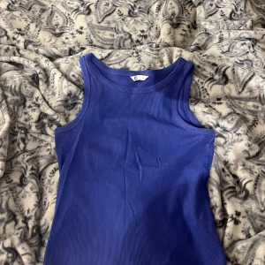 Blått linne - Säljer en snygg blå tank top i storlek S. Tröjan är ribbad och i fint skick!
