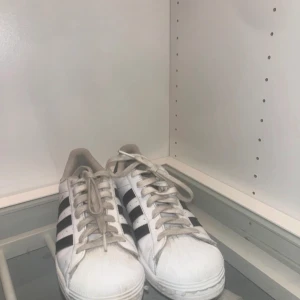 Adidas Superstar sneakers - Klassiska Adidas Superstar sneakers i vitt med svarta ränder. Skorna har snörning - Buda eller skriv gärna🧸