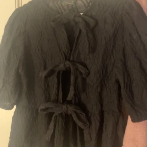 Tröga med rosetter framtill  - Söt tröja från gina tricot 