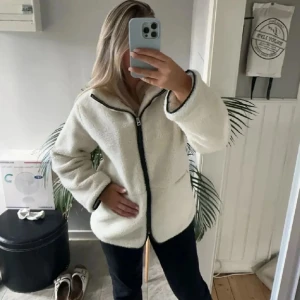 Vit teddyjacka med dragkedja - (Lånade  bilder från tjejen jag köpte av). Mysig vit teddyjacka med svart dragkedja och långa ärmar. Perfekt nu till våren. Säljer den då jag har en liknande jacka❣️