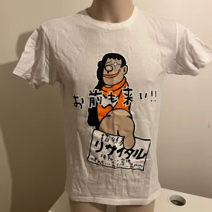 Vit t-shirt med japanskt tryck från Printstar - Säljer en vit t-shirt köpt i Tokyo från Printstar med ett unikt japanskt tryck på framsidan. Ingen aning om vad det står 🤣 T-shirten har korta ärmar och är tillverkad i bomull. Perfekt för dig som gillar annorlunda och roliga motiv!