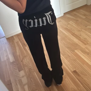 Juicy byxor/priset kan diskuteras  - Snygga svarta mjukisbyxor från Juicy Couture med glittrande strassdetaljer på baksidan och logotyp på benet. Byxorna har en bekväm passform med dragsko i midjan.