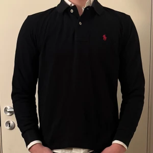 Svart långärmad pikétröja  Ralph Lauren - Snygg svart långärmad pikétröja från Ralph Lauren. Storleken är Small! Tveka inte på att hör av dig!