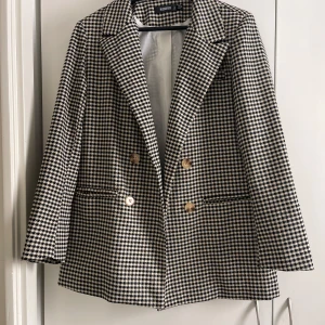 Rutig kavaj från Bubbleroom - Snygg rutig kavaj från Missguided med dubbelknäppning och klassisk krage. Kavajen har långa ärmar och två framfickor. Perfekt för en stilren look.